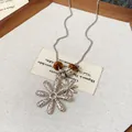 Close-up detail of silver daisy pendant necklace featuring natural tiger eye beads and chain - Double Flower Pendant Style / Silver