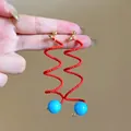 Eleganti orecchini a spirale con perline rosse e una sfera blu brillante a contrasto - Spiral Beaded Drop Style / Rosso