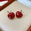 Close-up of elegant red enamel apple stud earrings with shiny zirconia leaf detail. - Apple Shape (WE5611) / Red
