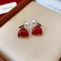 Close-up detail of red enamel tulip earrings with pearls and green leaves accents - Tulip Shape (WE5610) / Red