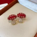 Detailed view of exquisite red enamel and zircon mushroom stud earrings on velvet - Mushroom Shape (WE5419) / Red