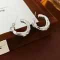 Boucles d'oreilles créoles vintage argentées avec nœud torsadé sur une boîte en velours - Style Forme en C Nœud Torsadé (23) / Argent