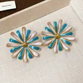 Detailed macro view of stylish flower stud earrings with blue and white enamel petals - Enamel Flower Style / Blue