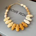 Detailed macro view of vintage resin necklace featuring irregular marble-textured amber beads - White-Coffee