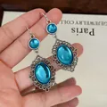 Primo piano di orecchini vintage con pietre di resina turchese e dettagli in filigrana. - Ciondolo Ovale a Gancio / Argento Blu