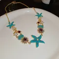 Detailed close-up view of a resort style necklace with turquoise starfish and shell charms. - 17# Necklace-Gold-Blue