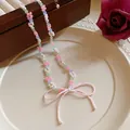 Detailed macro view of handmade beaded flower necklace with a charming large pink bow (82 chars) - Necklace / Pink-White
