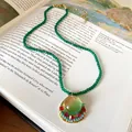 Close-up of a vintage French court style green beaded necklace with circular resin pendant - Necklace-Green