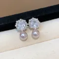 Close-up detail of elegant zircon flower earrings with pink pearl drops on beige fabric - Silver-Pink