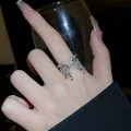 Gros plan d'une bague ouverte en argent avec cristaux marquise suspendus au doigt - Gland (4#) / Argent