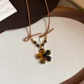 Detail view of a Maillard style tiger eye flower necklace with a brown leather cord. - Necklace-Coffee-Tiger Eye-Flower
