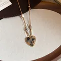 Close-up of heart-shaped leopard print necklace with tiger eye stone beads in warm brown tones. - Necklace-Brown-Heart