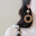 Gros plan de boucles d'oreilles rondes en rotin de style bohème sur l'oreille d'un modèle - Style Anneau Tissé en Rotin / 3# Tige d'oreille en acier-Café-Rond