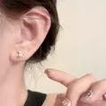 Elegant gold-tone Saturn orb stud earring with pearl and crystal detail on model ear - 25# Silver Post - Saturn Orb Style / Silver