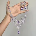 Vue détaillée d'un ensemble élégant de collier et boucles d'oreilles en strass violets. - Ensemble 2 pièces argenté et violet