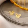 Elegant golden butterfly stud earrings with fine textured finish on grey jewelry pad - 65# Silver Earring Post - Gold