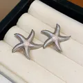 Detailed view of silver-toned starfish stud earrings with pink enamel inlay - Brown