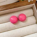 Elegant vibrant hot pink round dome stud earrings with glossy finish in a jewelry box - Red