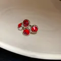 Primer plano de un clip de oreja vintage plateado con cuatro cristales rojos redondos - 38# Clip de Oreja de Gema Roja Plateada (Individual)