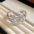 Close-up detail of a silver-toned wide intertwined cuff bracelet in a jewelry tray - Horseshoe Buckle Design / Silver