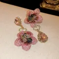 Gros plan sur des boucles d'oreilles asymétriques avec tissu floral rose et cristaux - Style Floral Asymétrique (HE8795) / Rose