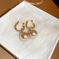 Detail shot of French-style gold twisted hoop earrings with large champagne pearls. - 17# Earring - Gold Pearl