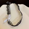 Close-up of black mesh lace choker necklace with a white bow detail and extender chain - Black and White Contrast Bowknot Style