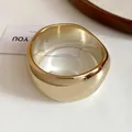 Macro detail view of minimalist gold resin bangle with smooth irregular geometric design - Gold