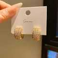 Macro view of luxury gold-plated hoop earrings with pave-set cubic zirconia crystals - C-Shaped Half Hoop (7) / Gold