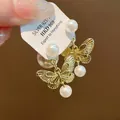 Detailed close-up of gold butterfly earrings with pearls and S925 silver post. - Butterfly Pearl Stud Earrings (Silver Post) / Gold