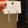 Close-up of silver-plated long bar earrings with pavé crystal inlay on display card. - Geometric Bar Dangle Style (10) / Silver