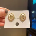 Vintage court style gold oval earrings with rose relief and mother of pearl inlay on white card - Rose Embossed Oval Style (28) / Gold