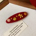 Nahaufnahme einer festlichen roten Filz-Haarklammer mit goldenen Glücksbringer-Details - 70# BB Clip-Gold/Rot-Einzelstück