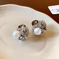 Gros plan détaillé de boucles d'oreilles vintage en argent avec fleur et perle. - Argent
