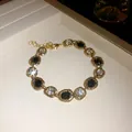 Elegant gold necklace with black and clear crystals set in irregular oval frames - Bracelet / Gold Base Black and White Stones