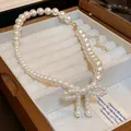 Elegant white pearl necklace featuring a delicate pearl-studded bow knot pendant. - Style 17 Necklace