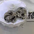 Close-up of vintage twisted flower stud earrings with a shiny silver metallic finish - Earring Posts / Silver