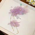 Vue détaillée d'une pince à cheveux fleur en tissu violet avec perles et glands dorés - Pince à Bec de Canard Fleur Violette / 1 Pièce / Violet