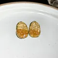 Macro detail of oval stud earrings featuring yellow and orange crushed crystal inlay - Oval Geometric Style / Silver Earring Post - Champagne