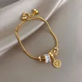 Bracelet serpent doré réglable élégant avec de jolies breloques cœur et cristal. - Or