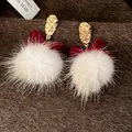 Detailansicht der eleganten roten Samtschleifen-Ohrringe mit weißen flauschigen Pelzpompons. - Schleife Pelzball Stil (Silberstift Gold) / Rot und Weiß