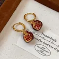 Detail of gold-plated hoop earrings with red zircon pomegranate pendants and enamel - Red Pomegranate Ear Buckle