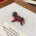 Macro view of an elegant vintage red enamel horse brooch with sparkling rhinestones - Red
