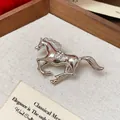 Detailed macro view of a silver running horse brooch with sparkling rhinestones. - Silver