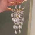 Elegant long tassel earrings with white pearls and sparkling zircons in gold finish - Hook Style / White