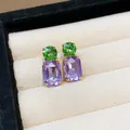 Close-up of rectangular purple and round green crystal stud earrings in jewelry box - Gold-Purple