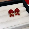 Close-up view of elegant vintage red pearl earrings with pavé crystal flower detail. - Gold-Red