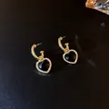 Close-up of vintage gold hoop earrings with black heart stones and shiny rhinestones - Silver Needle - Black Heart (HE5766)