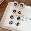 Détail de boucles d'oreilles pendantes rondes léopard avec bords dorés texturés. - Style Long Tige en Acier (HE28282) / Léopard Or-Café