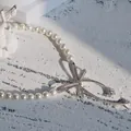 Elegant pearl necklace with a sparkling rhinestone bow pendant in white finish. - 21# Necklace / White
